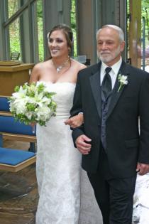 There is no prouder moment for a father than when he is walking with his daughter down the aisle. This wedding photo shows a beautiful bride with her dad as she's about to tie the knot.  